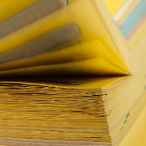 Yellow telephone book pages up close.