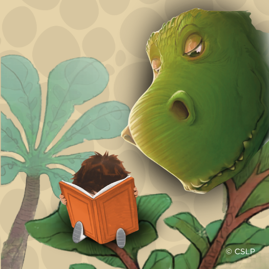 Young child sitting behind a large orange book with dinosaur head peeking down from right corner.