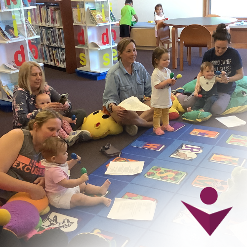 Young children and caregivers participating in storytime at library.