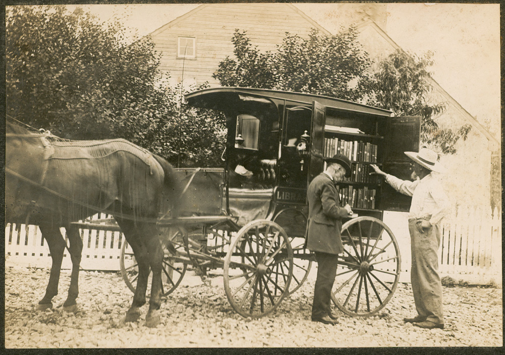 Horse and bookmobile wagon; 2 men looking through books