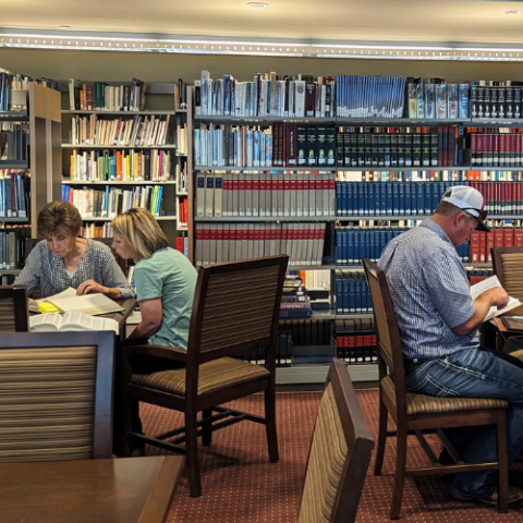 People sitting at tables in the library.