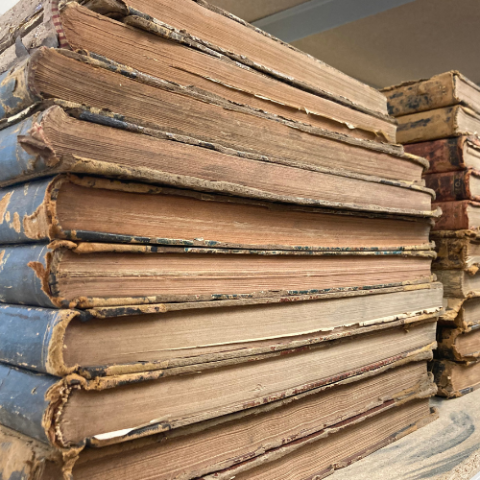 Stack of large, old books.