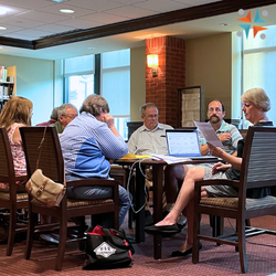 Adults sitting at a table in the Western Maryland Room at the library