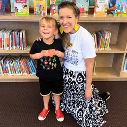 young child and woman kneeling in front of book case